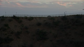 7.6K aerial stock footage ascending over a ridge to reveal Downtown Los Angeles, California at sunset Aerial Stock Footage | AX0162_104