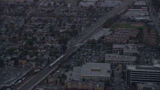 7.6K aerial stock footage of a Metrolink commuter train passing neighborhoods at twilight in Burbank, California  Aerial Stock Footage | AX0162_113