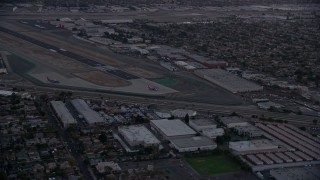 7.6K aerial stock footage of commercial airplanes on the end of the runway at Burbank Airport, California, twilight Aerial Stock Footage | AX0162_115