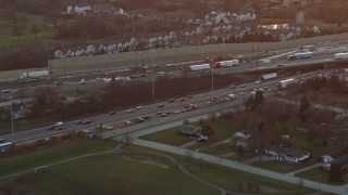 AX0163_0013 - 4K aerial stock footage a reverse view of heavy traffic on a freeway interchange at sunset in Burr Ridge, Illinois