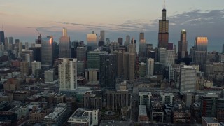 4K aerial stock footage of slowly flying by the Downtown Chicago skyscrapers at sunset, Illinois Aerial Stock Footage | AX0163_0027