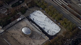 AX0165_0040 - 4K aerial stock footage of the Cloud Gate sculpture and ice skating rink at Grant Park, Downtown Chicago, Illinois