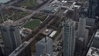 AX0165_0074 - 4K aerial stock footage of flying by the Cloud Gate sculpture and ice skating rink at Grant Park, Downtown Chicago, Illinois