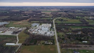 4K aerial stock footage of flying over a manufacturing plant, fields and farms in Franksville, Wisconsin Aerial Stock Footage | AX0167_0041