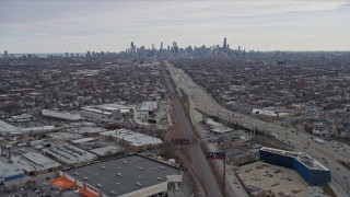 4K aerial stock footage of following light freeway traffic, tilt to reveal wide view of Downtown Chicago skyline, Illinois Aerial Stock Footage | AX0167_0078