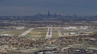 4K aerial stock footage of a reverse view of the Downtown Chicago skyline and Chicago Midway International Airport, Illinois Aerial Stock Footage | AX0168_0014