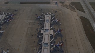 4K aerial stock footage of commercial planes at terminals at Chicago Midway International Airport at sunset, Illinois Aerial Stock Footage | AX0169_0106