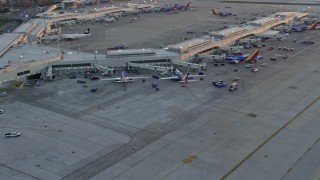 4K aerial stock footage of flying away from Southwest jets at Chicago Midway International Airport at sunset, Illinois Aerial Stock Footage | AX0170_0002