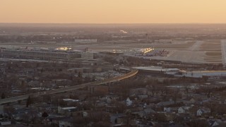 4K aerial stock footage of flying away from Chicago Midway International Airport at sunset, Illinois Aerial Stock Footage | AX0170_0003