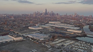 AX0170_0006 - 4K aerial stock footage the distant Downtown Chicago skyline seen from West Side warehouses at sunset, Illinois