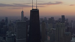 4K aerial stock footage of flying away from John Hancock Center, tilt to reveal Lake Shore Drive at sunset, Downtown Chicago, Illinois Aerial Stock Footage | AX0170_0021