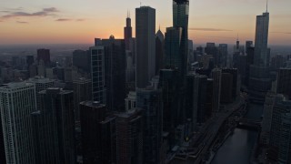 4K aerial stock footage focus on the setting sun while flying by skyscrapers in Downtown Chicago, Illinois Aerial Stock Footage | AX0170_0024