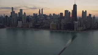 4K aerial stock footage tilt from the lake to reveal waterfront skyscrapers and distant sunset, Downtown Chicago, Illinois Aerial Stock Footage | AX0170_0031