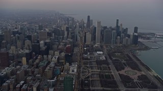 4K aerial stock footage of following Michigan Avenue by Grant Park toward skyscrapers at sunset, Downtown Chicago, Illinois Aerial Stock Footage | AX0170_0040