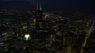 4K aerial stock footage of flying by Willis Tower with holiday lights at night, Downtown Chicago, Illinois Aerial Stock Footage | AX0170_0070