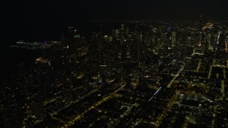 4K aerial stock footage a view of downtown skyscrapers, some with holiday lights at night, Downtown Chicago, Illinois Aerial Stock Footage | AX0170_0083