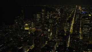 4K aerial stock footage fly over downtown skyscrapers, some with holiday lights, toward Grant Park at night, Downtown Chicago, Illinois Aerial Stock Footage | AX0170_0084