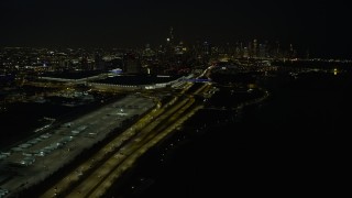 4K aerial stock footage the downtown skyline seen from McCormick Place and State Route 41 at night, Downtown Chicago, Illinois Aerial Stock Footage | AX0170_0086