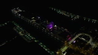 4K aerial stock footage of tilting to a bird's eye view of the Ferris wheel on Navy Pier at night, Chicago, Illinois Aerial Stock Footage | AX0170_0094