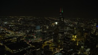 4K aerial stock footage of the Willis Tower skyscraper with holiday lights at night, Downtown Chicago, Illinois Aerial Stock Footage | AX0170_0097