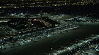 AX0170_0113 - 4K aerial stock footage a reverse view of the terminals at O'Hare International Airport at night, Chicago, Illinois