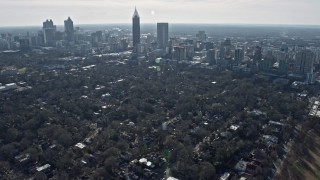 AX0171_0100 - 6.7K aerial stock footage tilt from high school and football field to reveal Downtown and Midtown Atlanta, Georgia