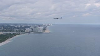 6.7K aerial stock footage of a commercial airplane flying over the water toward Fort Lauderdale, Florida Aerial Stock Footage | AX0172_040