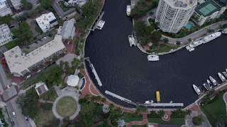 6.7K aerial stock footage tilt to bird's eye of a ferry sailing toward a dock and New River in Downtown Fort Lauderdale, Florida Aerial Stock Footage | AX0172_057