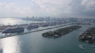 6.7K aerial stock footage of flying by islands and cruise ships at the port with view of the downtown skyline in Miami, Florida Aerial Stock Footage | AX0172_126