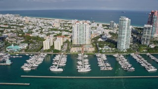 6.7K aerial stock footage tilt from bay to reveal and fly over condo complex, South Beach, Miami, Florida Aerial Stock Footage | AX0172_130