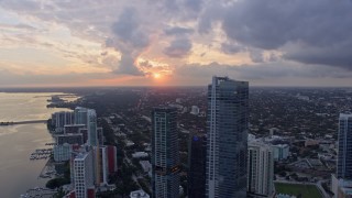 6.7K aerial stock footage focus on setting sun while flying by Downtown Miami skyscrapers, Florida at sunset Aerial Stock Footage | AX0172_169