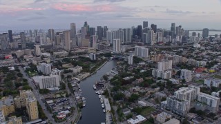 6.7K aerial stock footage tilt from river to reveal and approach downtown skyscrapers at sunset, Miami, Florida Aerial Stock Footage | AX0172_182