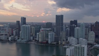 6.7K aerial stock footage of the setting sun behind waterfront skyscrapers in Downtown Miami, Miami, Florida Aerial Stock Footage | AX0172_187