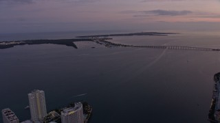 6.7K aerial stock footage tilt from Downtown Miami skyscrapers to reveal Rickenbacker Causeway at twilight, Florida Aerial Stock Footage | AX0172_206