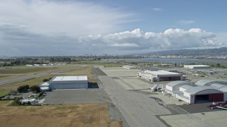 6K aerial stock footage of flying over Oakland Airport toward the distant skyline of Downtown Oakland, California Aerial Stock Footage | AX0173_0001