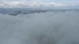 6K aerial stock footage fly above fog with a view of the San Francisco skyline, California Aerial Stock Footage | AX0173_0093