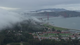 AX0173_0095 - 6K aerial stock footage the Golden Gate Bridge seen from a fog bank over The Presidio, California