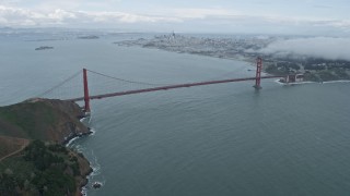 AX0173_0100 - 6K aerial stock footage of flying over fog above Marin Headlands, reveal Golden Gate Bridge, California