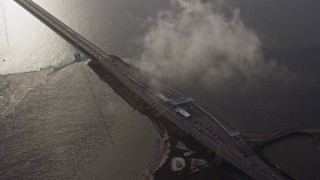 6K aerial stock footage flying away from the San Mateo Bridge, reveal toll booth, Hayward, California Aerial Stock Footage | AX0174_0007