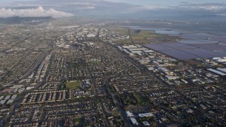 AX0174_0013 - 6K aerial stock footage of flying over Newark homes toward warehouse buildings, California