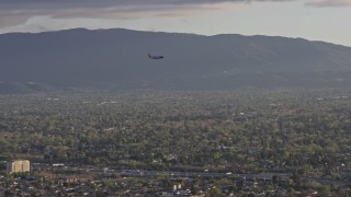 6K aerial stock footage of a commercial airplane flying over San Jose at sunset, California Aerial Stock Footage | AX0174_0030