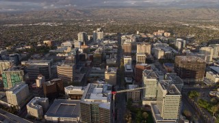 AX0174_0038 - 6K aerial stock footage of approaching and flying over office buildings in Downtown San Jose at sunset, California