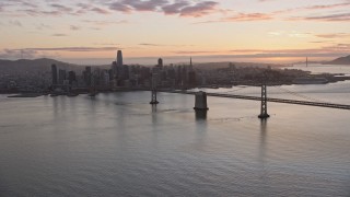 6K aerial stock footage a wide view of the Bay Bridge and the Downtown San Francisco skyline at sunset, California Aerial Stock Footage | AX0174_0087