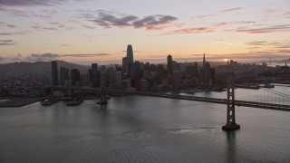 AX0174_0091 - 6K aerial stock footage of approaching the Bay Bridge and the Downtown San Francisco skyline at sunset, California