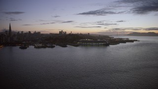 AX0174_0119 - 6K aerial stock footage of a cruise ship docked near Coit Tower at twilight, San Francisco, California