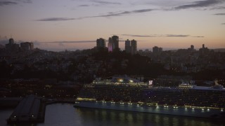 AX0174_0120 - 6K aerial stock footage of Coit Tower seen from a docked cruise ship at twilight, San Francisco, California