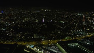 AX0174_0159 - 6K aerial stock footage of flying by Coit Tower at night, San Francisco, California