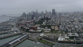 6K aerial stock footage flyby Coit Tower on a foggy day with Downtown San Francisco skyline in the background, California Aerial Stock Footage | AX0175_0024