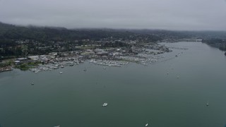 AX0175_0036 - 6K aerial stock footage of approaching marinas by coastal neighborhoods in Sausalito on a foggy day, California