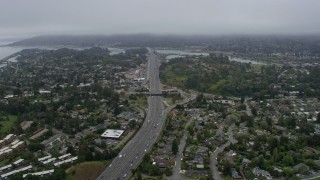 AX0175_0059 - 6K aerial stock footage following Highway 101 through Mill Valley on a foggy day, California